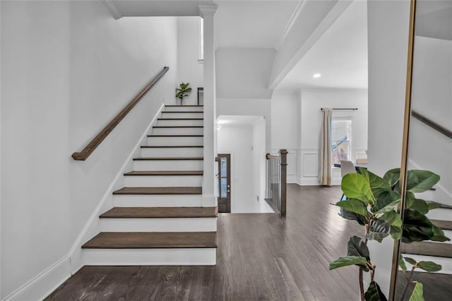 stairs featuring a wainscoted wall, a decorative wall, and wood finished floors