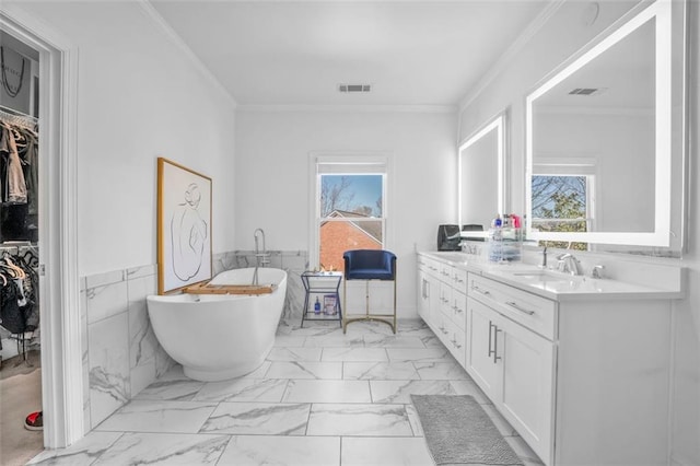 bathroom featuring double vanity, visible vents, marble finish floor, crown molding, and a healthy amount of sunlight