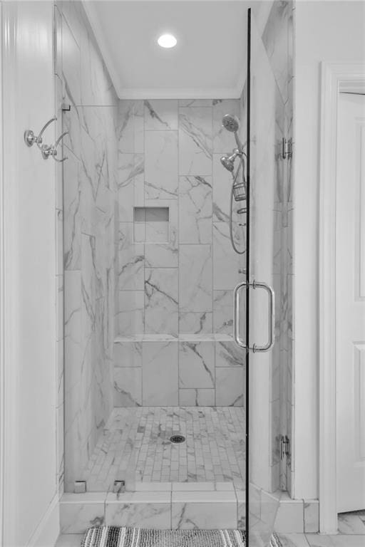 bathroom featuring marble finish floor, a marble finish shower, and crown molding