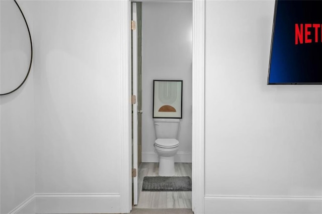 bathroom featuring toilet and baseboards