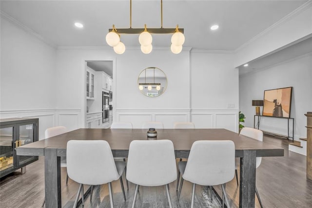 dining room featuring ornamental molding, recessed lighting, a decorative wall, and wood finished floors