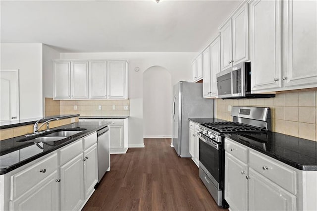 kitchen featuring dark hardwood / wood-style floors, stainless steel appliances, backsplash, white cabinets, and sink