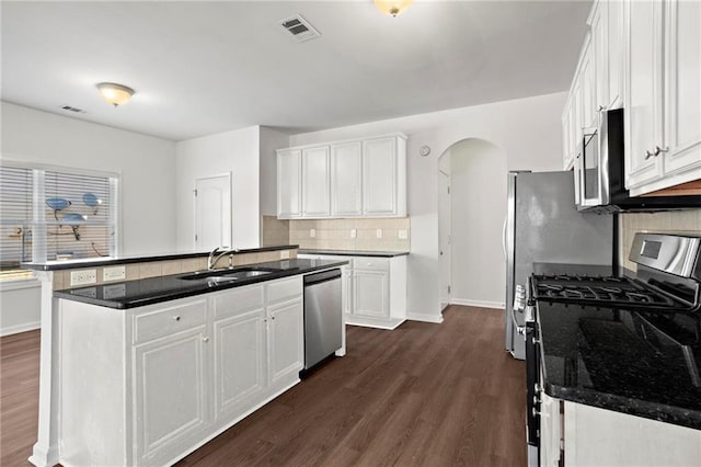 kitchen featuring white cabinets, a center island with sink, appliances with stainless steel finishes, and sink