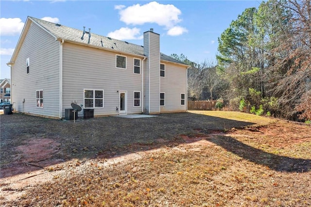 rear view of property featuring a lawn, cooling unit, and a patio