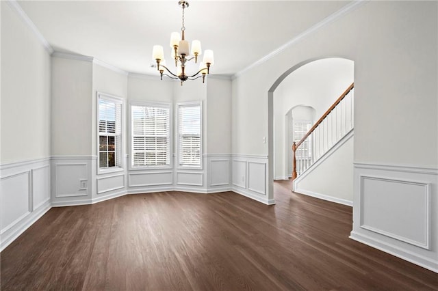 unfurnished dining area featuring dark hardwood / wood-style flooring, crown molding, and a chandelier