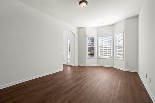 unfurnished room featuring dark wood-type flooring