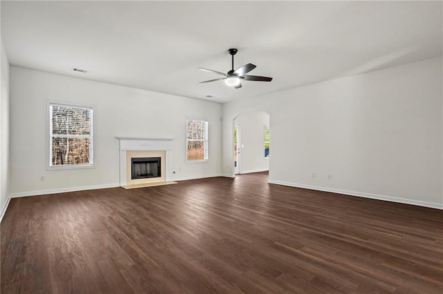 unfurnished living room featuring dark hardwood / wood-style flooring and ceiling fan