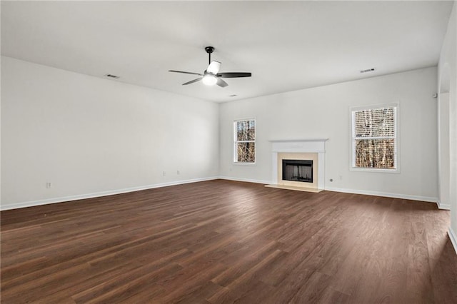 unfurnished living room featuring ceiling fan and dark wood-type flooring