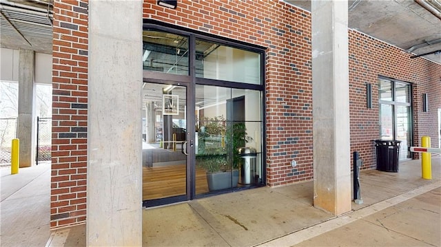 doorway to property featuring brick siding