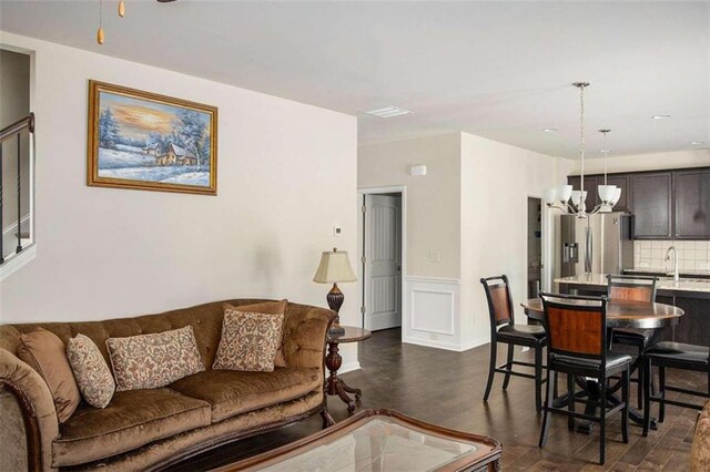 living room featuring dark wood-type flooring and an inviting chandelier