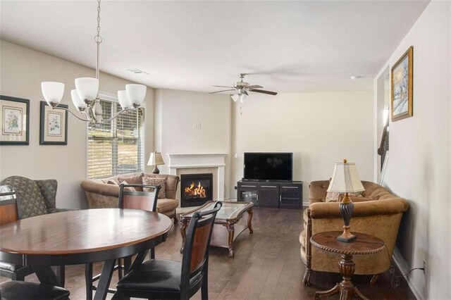 dining room with dark wood-type flooring and ceiling fan with notable chandelier