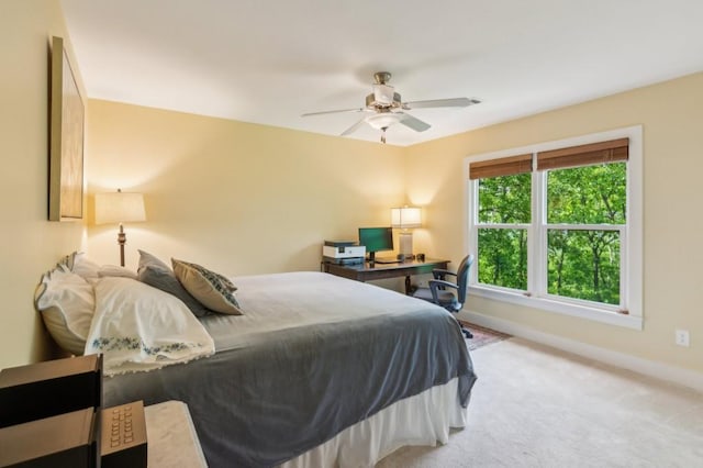 carpeted bedroom with baseboards, a ceiling fan, and an office area