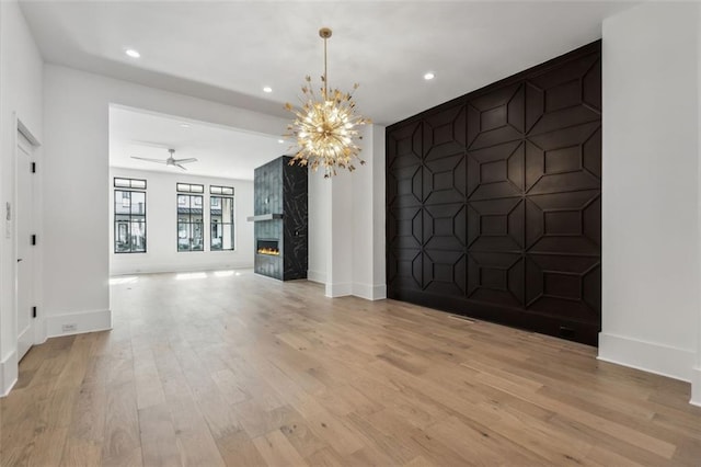 12632 Branyan Cir, Alpharetta, GA 30004 - unfurnished living room featuring light wood finished floors, recessed lighting, a chandelier, a premium fireplace, and a ceiling fan