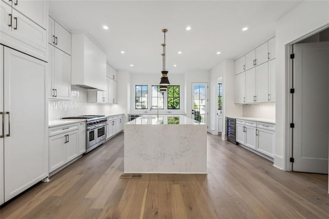 12632 Branyan Cir, Alpharetta, GA 30004 - kitchen featuring double oven range, beverage cooler, white cabinets, wood finished floors, and recessed lighting