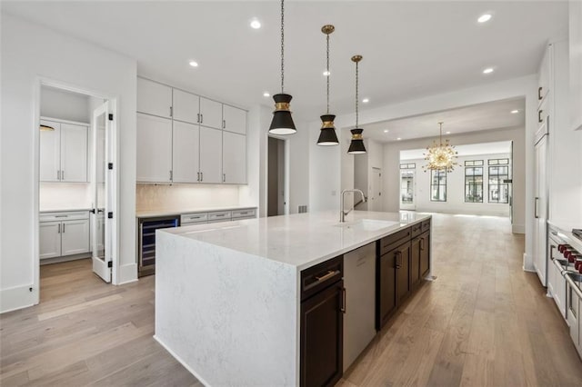 12632 Branyan Cir, Alpharetta, GA 30004 - kitchen featuring beverage cooler, recessed lighting, light wood-style flooring, white cabinets, and a large island with sink