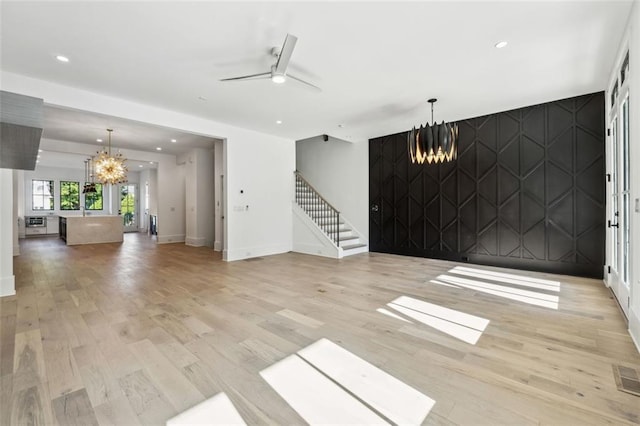 12632 Branyan Cir, Alpharetta, GA 30004 - unfurnished living room featuring a chandelier, light wood finished floors, an accent wall, recessed lighting, and a ceiling fan