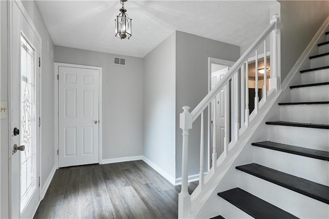 entryway with a notable chandelier and dark hardwood / wood-style flooring