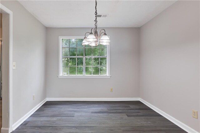 unfurnished room with dark hardwood / wood-style flooring and a chandelier