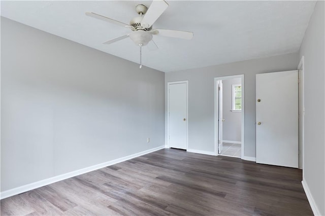 spare room with dark wood-type flooring and ceiling fan