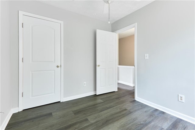 unfurnished bedroom featuring dark wood-type flooring and ceiling fan