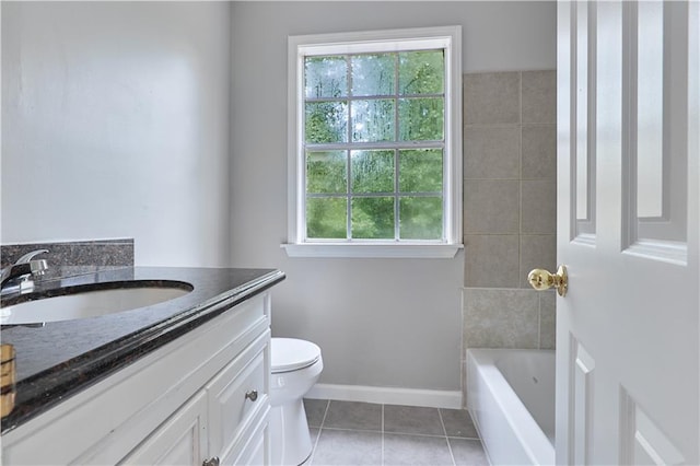 bathroom featuring tile patterned flooring, vanity, toilet, and a tub