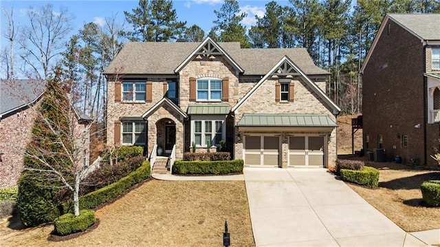 craftsman house with concrete driveway, a standing seam roof, central AC, metal roof, and a garage