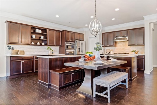 kitchen featuring under cabinet range hood, stainless steel appliances, dark wood-style floors, open shelves, and a center island with sink