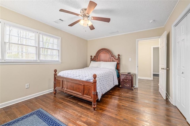 bedroom with visible vents, baseboards, dark wood finished floors, a textured ceiling, and a ceiling fan