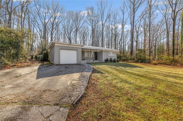 mid-century inspired home featuring aphalt driveway, an attached garage, and a front lawn