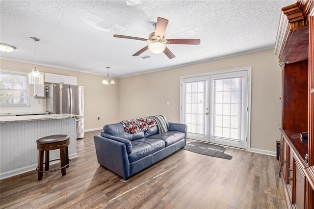 living room featuring visible vents, a healthy amount of sunlight, french doors, and wood finished floors