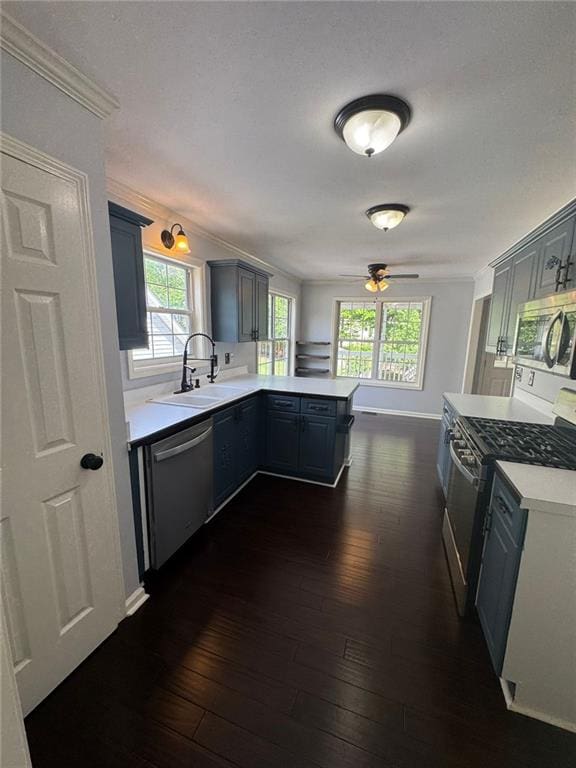 955 Tributary Way, Dacula, GA 30019 - kitchen with appliances with stainless steel finishes, a peninsula, a ceiling fan, light countertops, and dark wood-style flooring