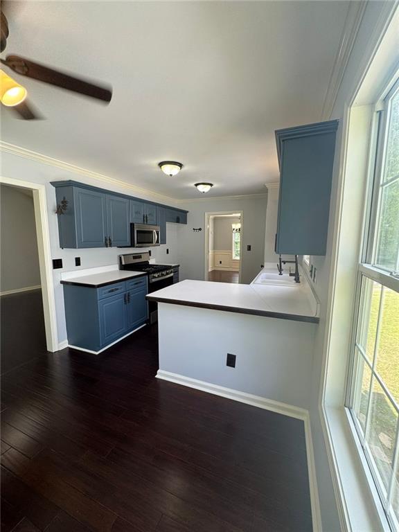 955 Tributary Way, Dacula, GA 30019 - kitchen featuring stainless steel appliances, blue cabinets, crown molding, light countertops, and a ceiling fan