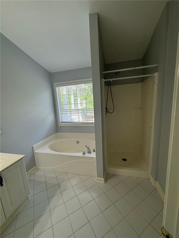 955 Tributary Way, Dacula, GA 30019 - bathroom featuring tile patterned floors, a garden tub, vanity, and a shower stall