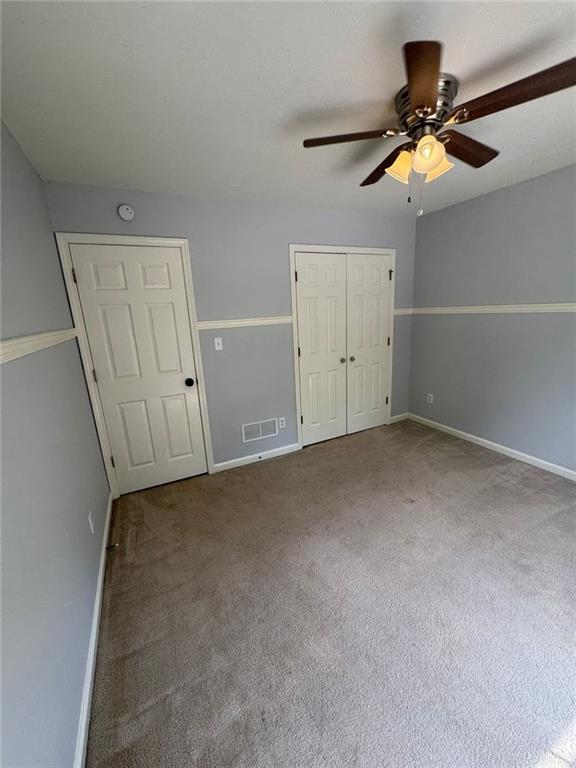 955 Tributary Way, Dacula, GA 30019 - unfurnished bedroom with carpet floors, a closet, and a ceiling fan