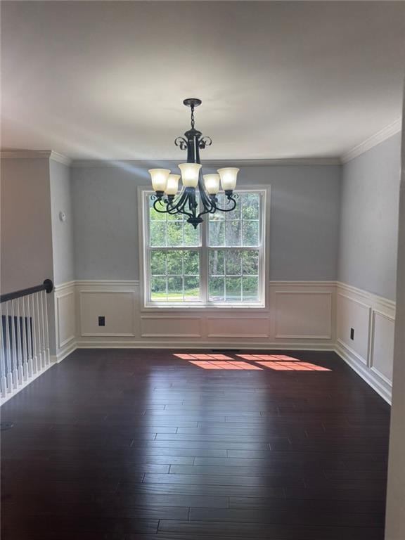 955 Tributary Way, Dacula, GA 30019 - unfurnished dining area featuring a chandelier, dark wood-type flooring, crown molding, a wainscoted wall, and a decorative wall