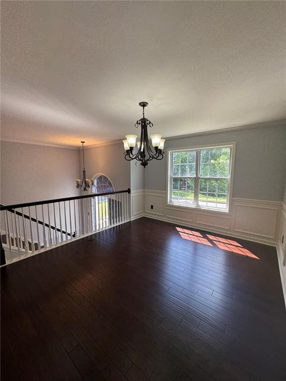 955 Tributary Way, Dacula, GA 30019 - unfurnished room featuring a chandelier, a wainscoted wall, a textured ceiling, wood finished floors, and ornamental molding