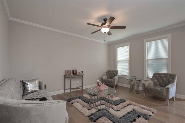 sitting room with wood-type flooring, ceiling fan, and crown molding