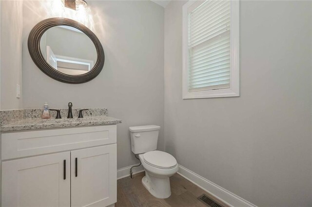 bathroom with hardwood / wood-style flooring, vanity, and toilet