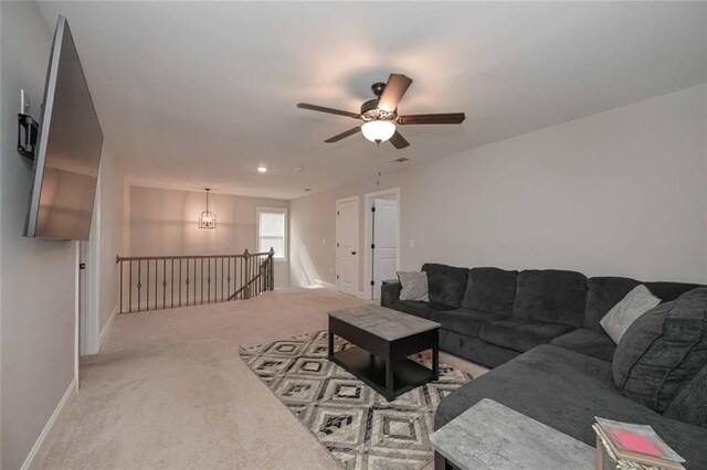 carpeted living room featuring ceiling fan