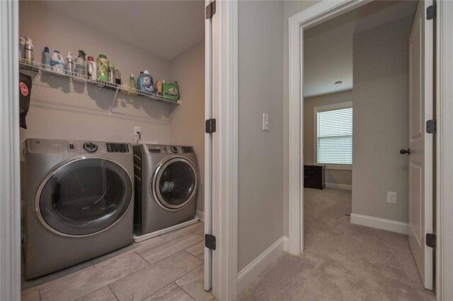 washroom with washing machine and dryer and light carpet