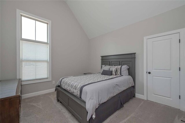 carpeted bedroom with lofted ceiling