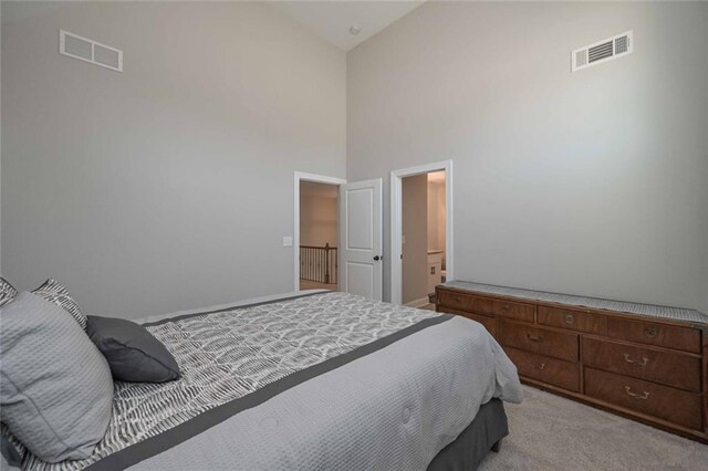 carpeted bedroom featuring a towering ceiling