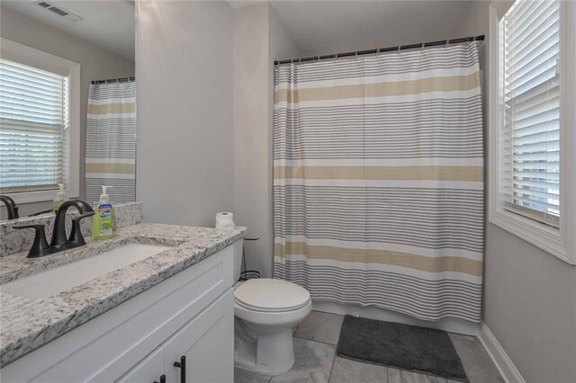 bathroom featuring vanity, a healthy amount of sunlight, and toilet