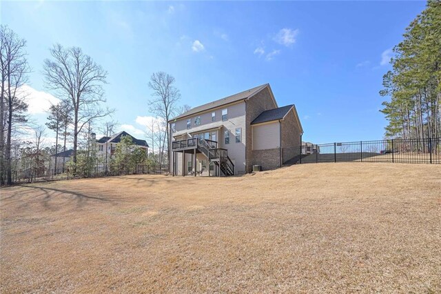 back of property with a deck and a lawn