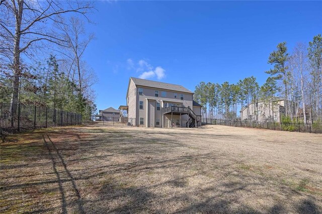 rear view of house featuring a wooden deck and a yard