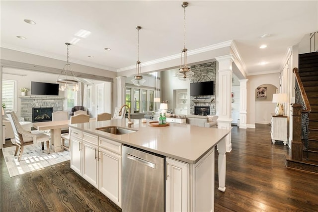 kitchen featuring stainless steel dishwasher, open floor plan, a stone fireplace, and a sink