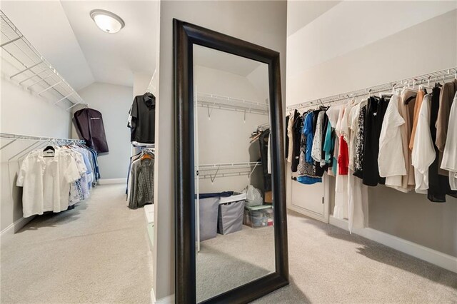 walk in closet featuring carpet floors and lofted ceiling
