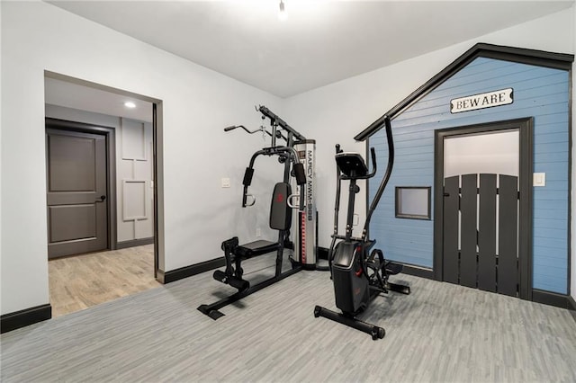 exercise room featuring baseboards and wood finished floors