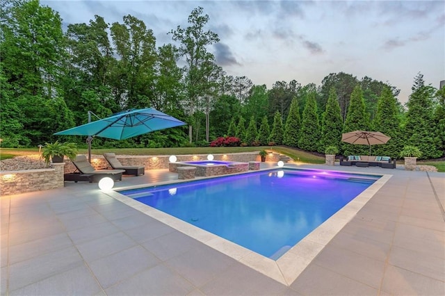outdoor pool with an outdoor hangout area, an in ground hot tub, and a patio area