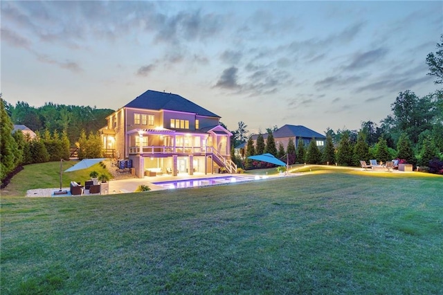 rear view of house with a lawn, a patio, stairs, and an outdoor pool